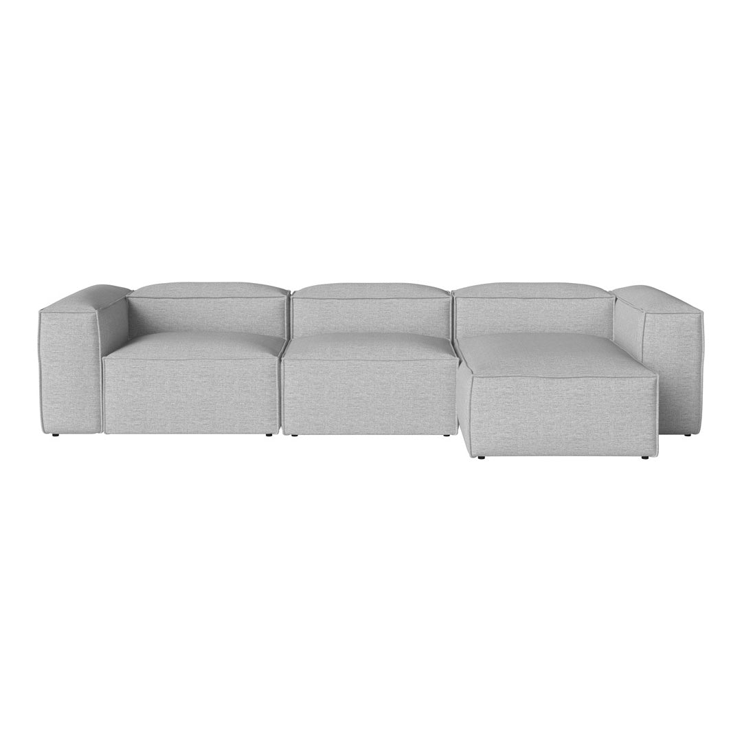 Gray sectional sofa with a minimalist design and soft fabric, featuring clean lines and a modern aesthetic.