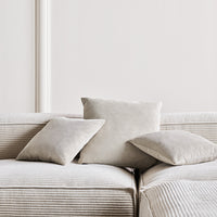 Light gray textured cushions on a striped beige sofa, creating a soft, cozy aesthetic. Ideal for modern decor.