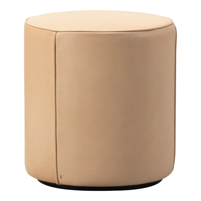 Round, soft beige ottoman with a smooth pattern and black base, perfect for modern decor.