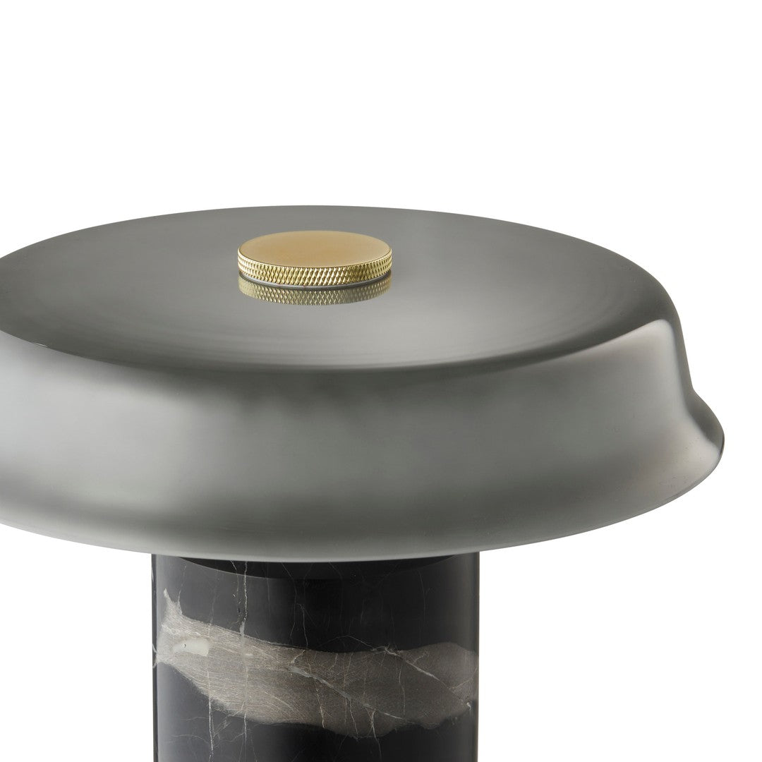 Round gray tabletop with a sleek finish, featuring a gold accent on a textured black pedestal. Modern design aesthetics.