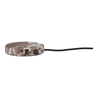 Brown marble patterned surface with shades of white and a black cord, round design, modern aesthetic.