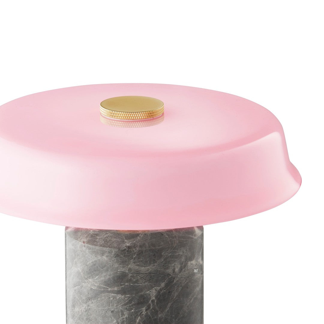 Pink dome-shaped lid with a gold accent atop a textured gray marble base. Modern and stylish design.