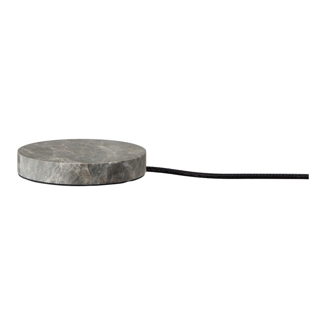 Round gray marble charging pad with a sleek, minimalist design and black cord. Ideal for modern decor.