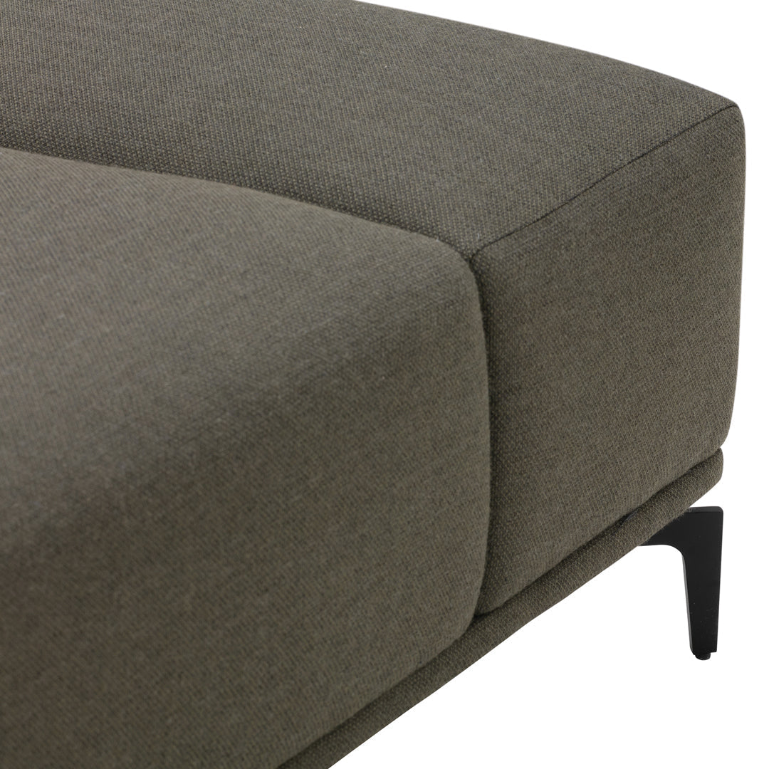 Gray upholstered sofa corner with smooth texture and modern black metal legs. Simple, contemporary design.