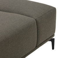 Gray upholstered sofa corner with smooth texture and modern black metal legs. Simple, contemporary design.