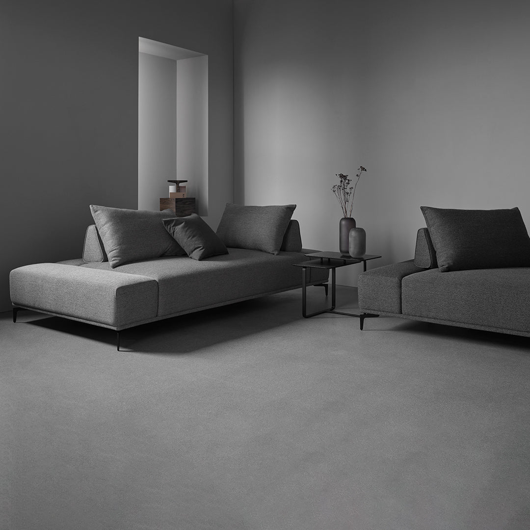 Modern gray sectional sofas with sleek lines and contrasting black accents in a minimalist living space.