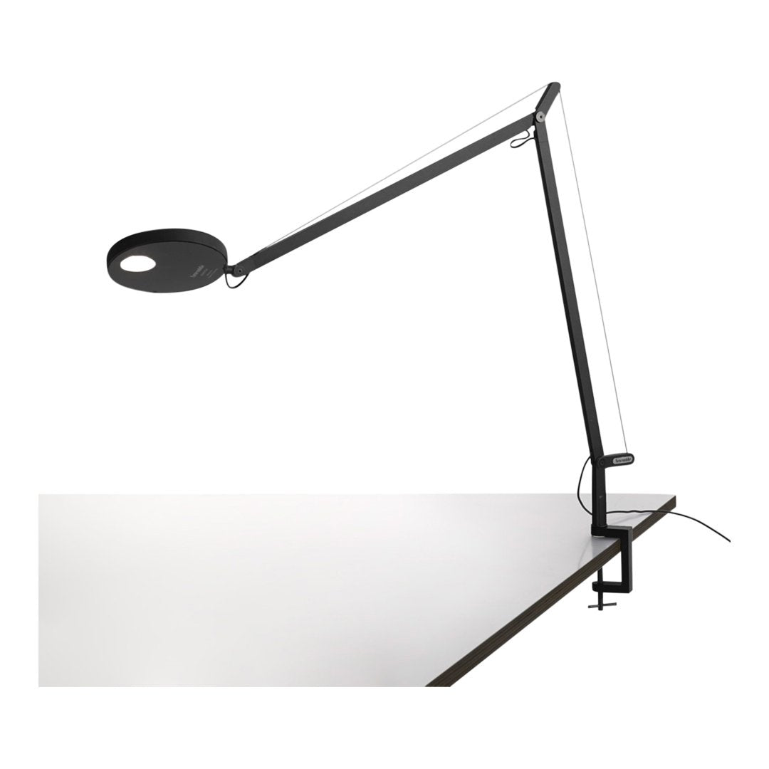 Modern black and white desk lamp with sleek lines and minimalist design, featuring a circular light.