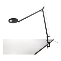 Modern black and white desk lamp with sleek lines and minimalist design, featuring a circular light.