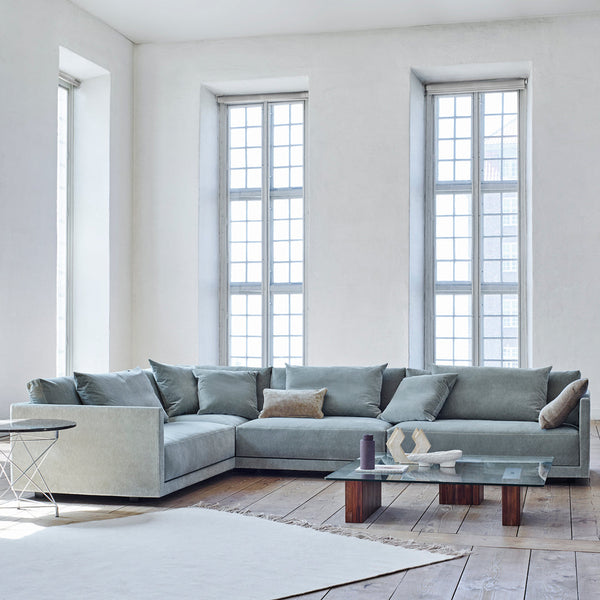 Light blue sectional sofa with textured fabric and matching pillows in a modern, airy interior setting.