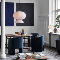 Modern dining room featuring deep blue velvet chairs and abstract wall art in hues of navy and charcoal. Elegant, minimalist design.