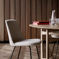 Neutral beige chair with a smooth fabric texture, set against a warm wooden backdrop and minimalistic design elements.