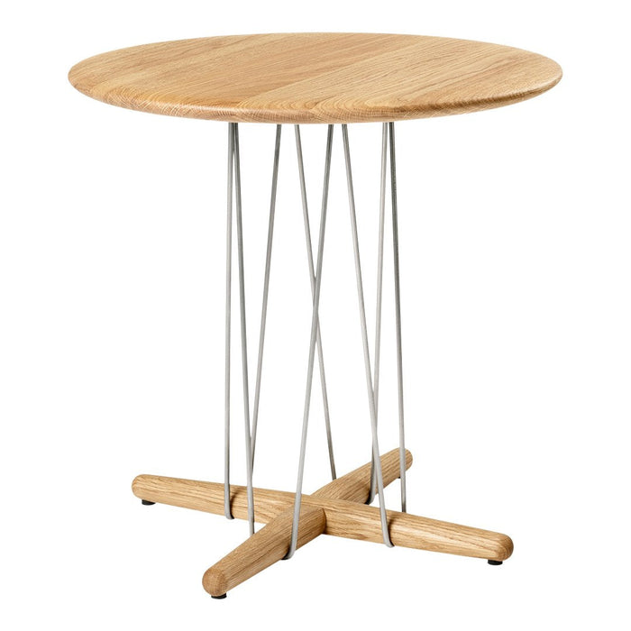 Light oak round table with a natural wood finish and modern silver metal legs, featuring a minimalist design.
