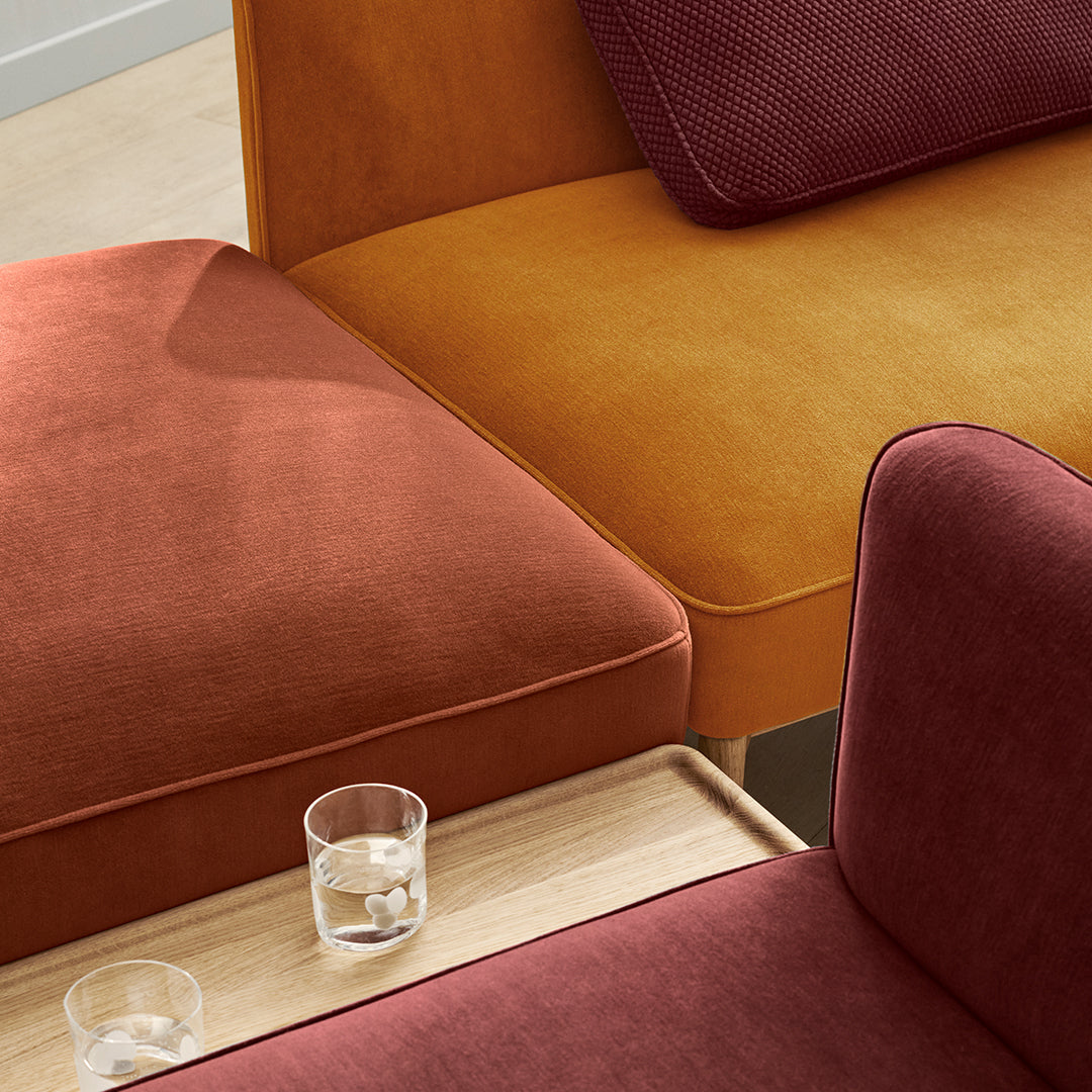 Colorful sofa sections in rich burgundy, vibrant orange, and warm mustard, featuring a smooth texture and modern design.