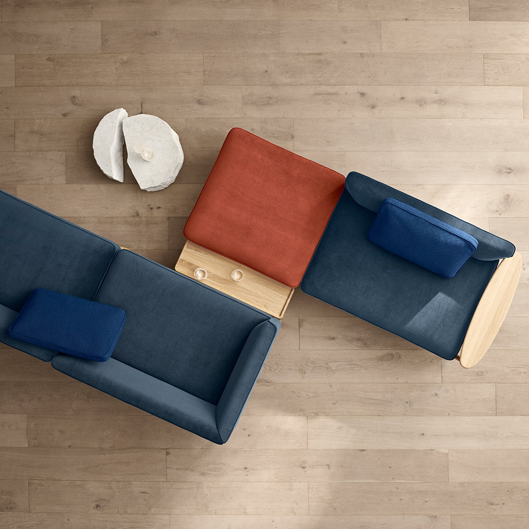"Blue and red sectional sofa with solid colors and soft textures, accompanied by a round white coffee table."