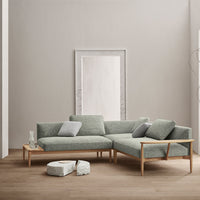 Modern light green sectional sofa with a textured fabric and natural wood legs, complemented by light gray cushions.