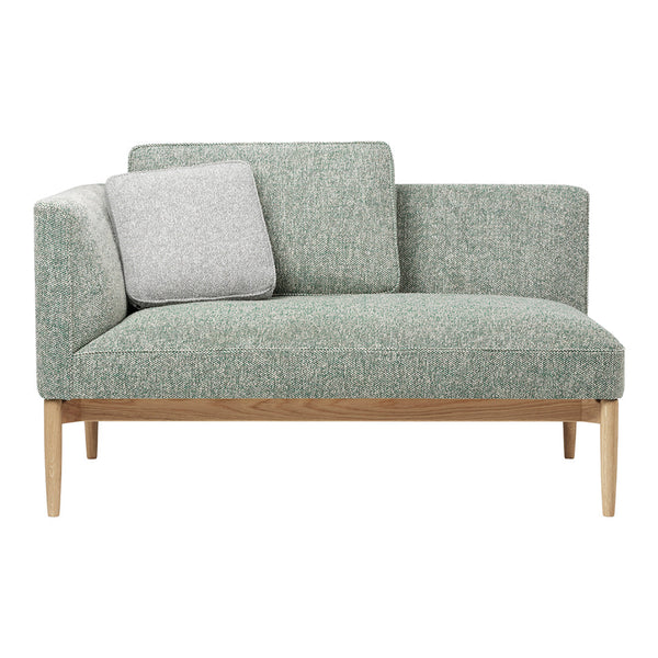 Light green upholstery with subtle texture, complemented by a grey accent pillow and natural wood legs.