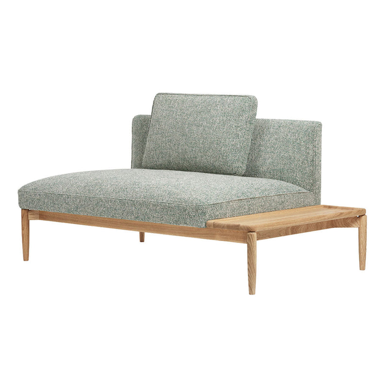 Textured green upholstery on a sleek, modern sofa with natural wood accents and minimalist design.