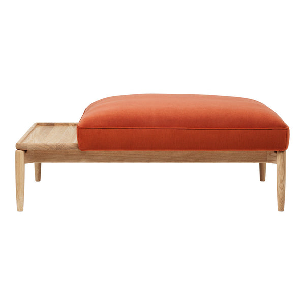 Orange cushion atop a light wood frame with a minimalist design and smooth surface. Modern and inviting aesthetic.