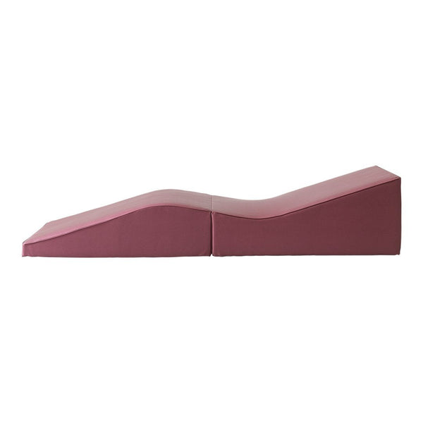 Pink foam wedge with smooth curves, featuring a modern minimalist design and a soft, solid color.