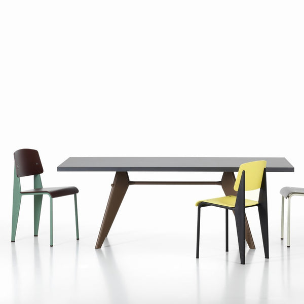 Modern table with a sleek black top and vibrant green, yellow, and brown patterned chairs.