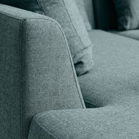 Soft gray upholstered couch with a textured, minimalist design and plush cushions.