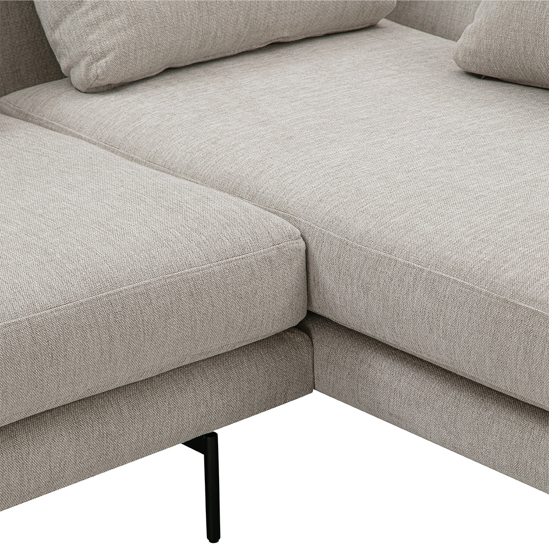 Light beige textured fabric sectional sofa with clean lines and subtle stitching details, featuring black metal legs.