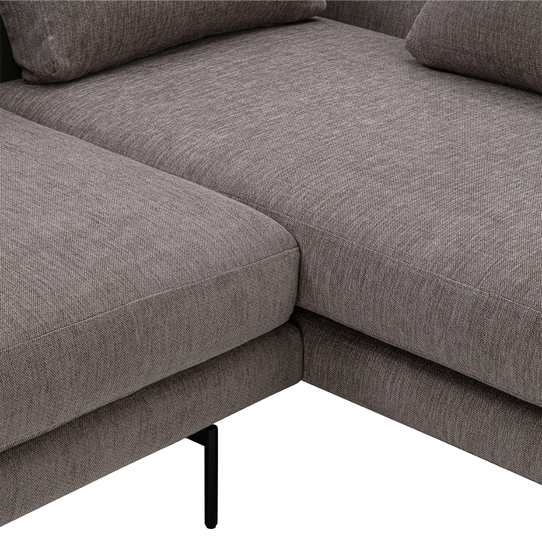 Gray textured fabric sectional sofa corner detail with sleek black metal legs.