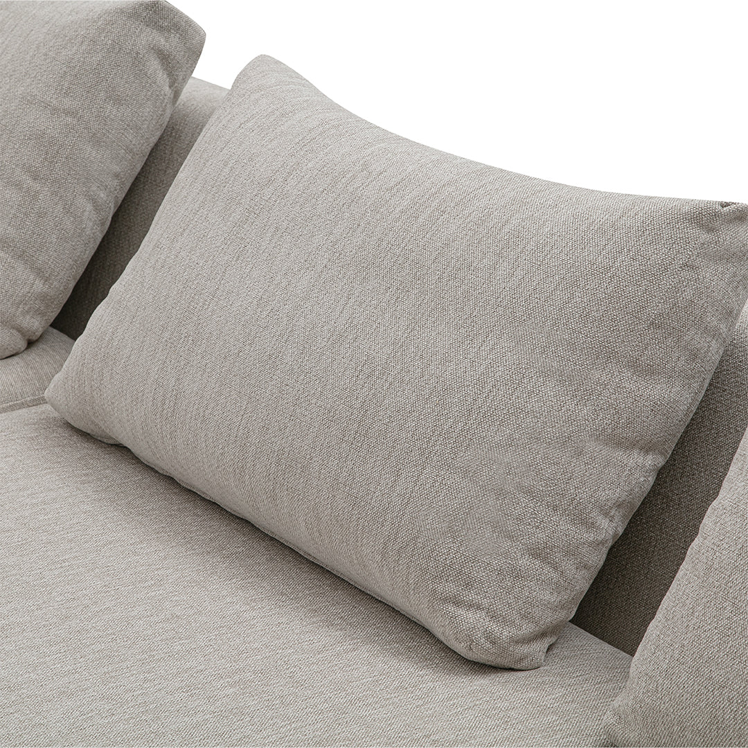 Light gray textured fabric pillow against a smooth gray backdrop, adding subtle elegance to modern decor.