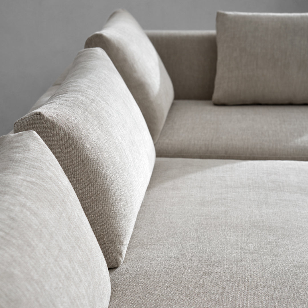 Neutral beige fabric sofa with a smooth, textured pattern and plush, supportive cushions.