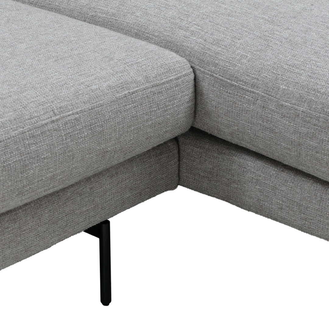 Gray textured fabric upholstery on sectional sofa with sleek black metal legs. Modern and versatile design.