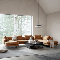 Modern L-shaped sofa in warm caramel hue with smooth fabric, paired with dark wood accents and light gray textiles.