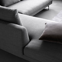 Gray modern sectional sofa with clean lines and a plush dark brown pillow for added contrast and texture.
