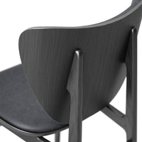 Sleek black chair with a textured wood grain back and smooth seat, showcasing modern design.