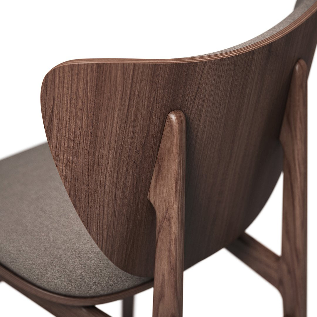 "Close-up of a modern wooden chair with a rich walnut finish and a textured gray seat cushion."