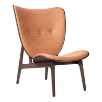 "Contemporary chair in warm tan leather with a smooth finish and subtle button details against a dark wooden frame."