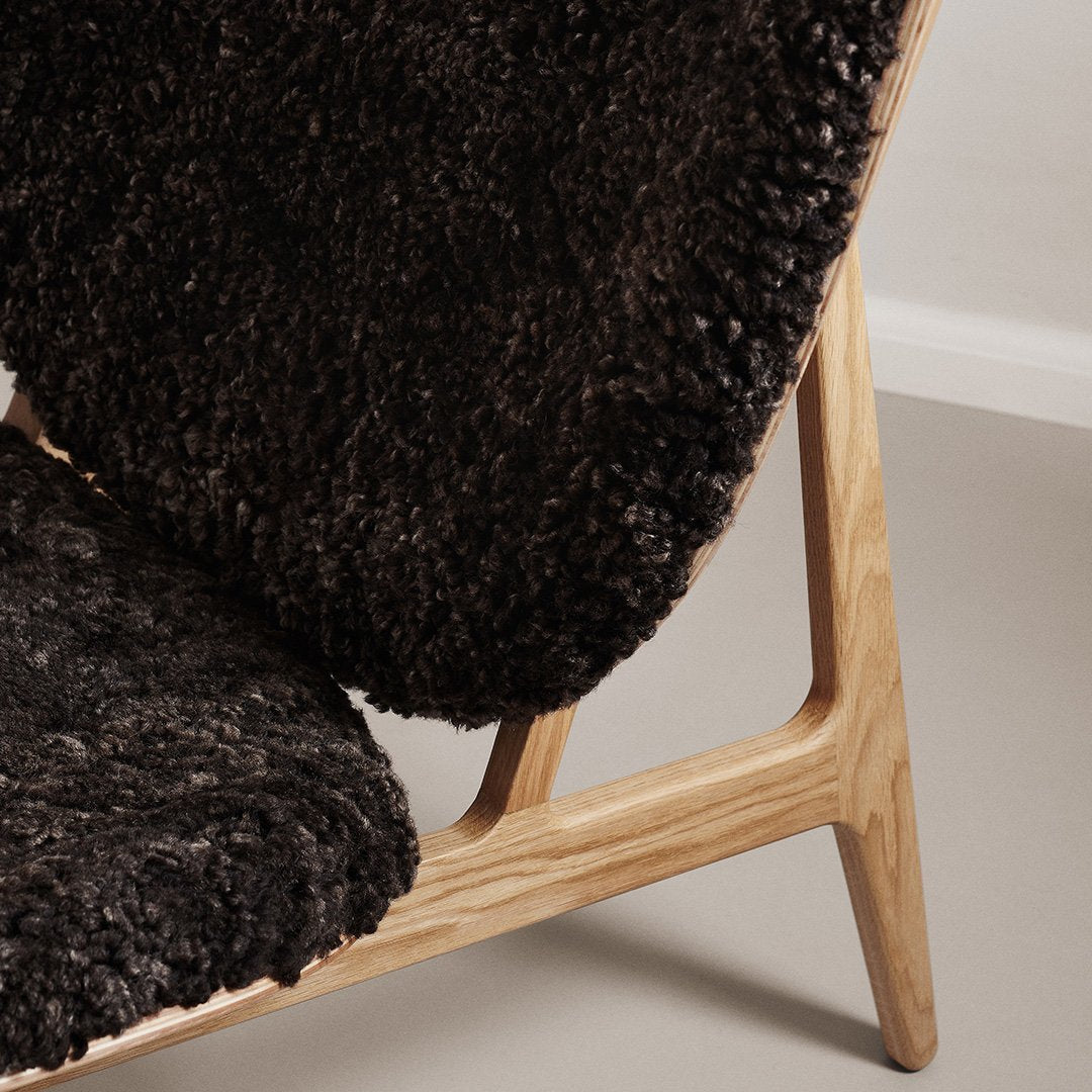 Cozy black and grey textured upholstery on a modern wooden chair, showcasing a soft, shaggy pattern.