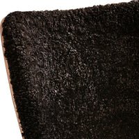 Textured black shag fabric with a plush, cozy appearance, perfect for modern home decor.
