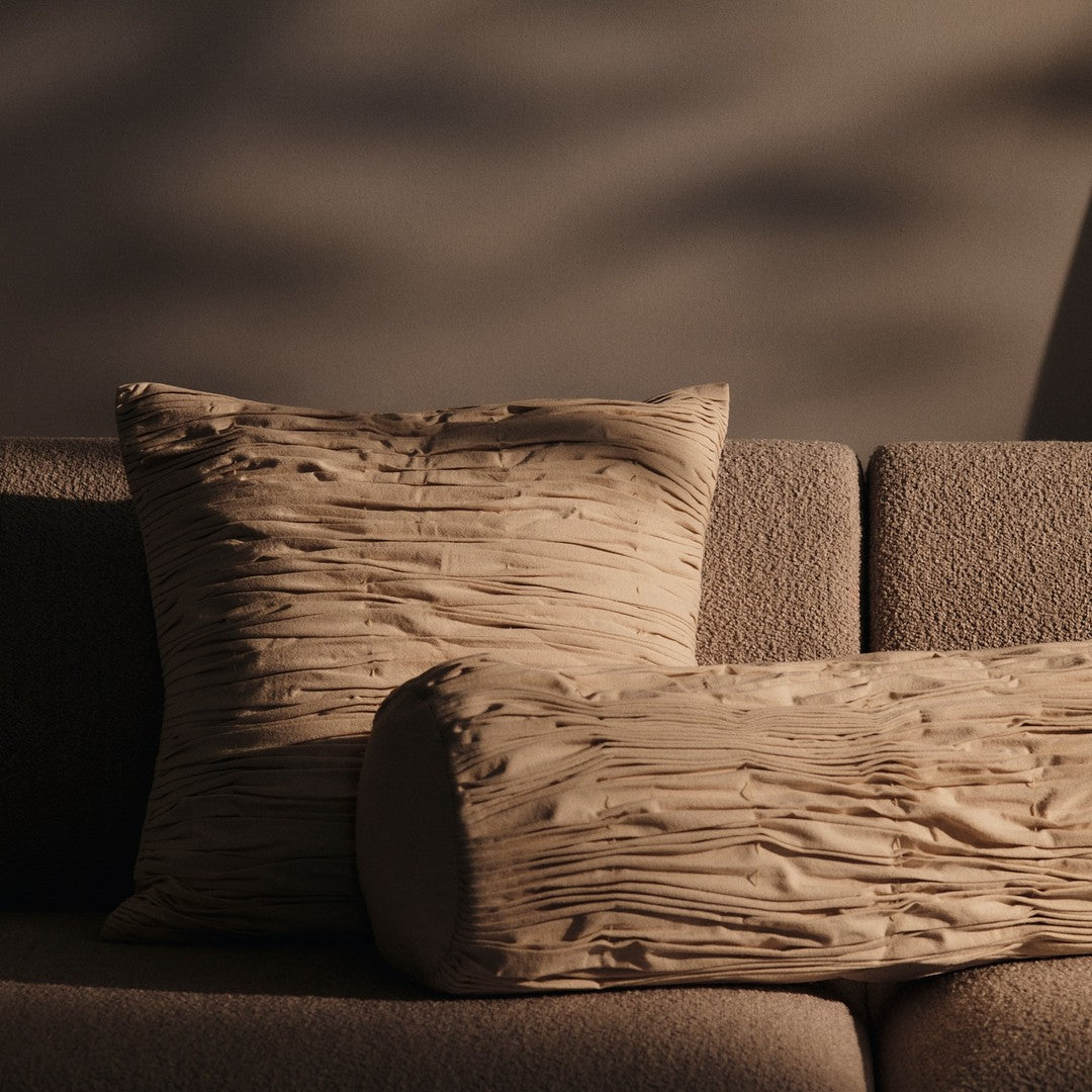 Textured beige pillows with subtle wrinkled patterns, perfect for adding warmth and style to any living space.