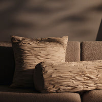Textured beige pillows with subtle wrinkled patterns, perfect for adding warmth and style to any living space.