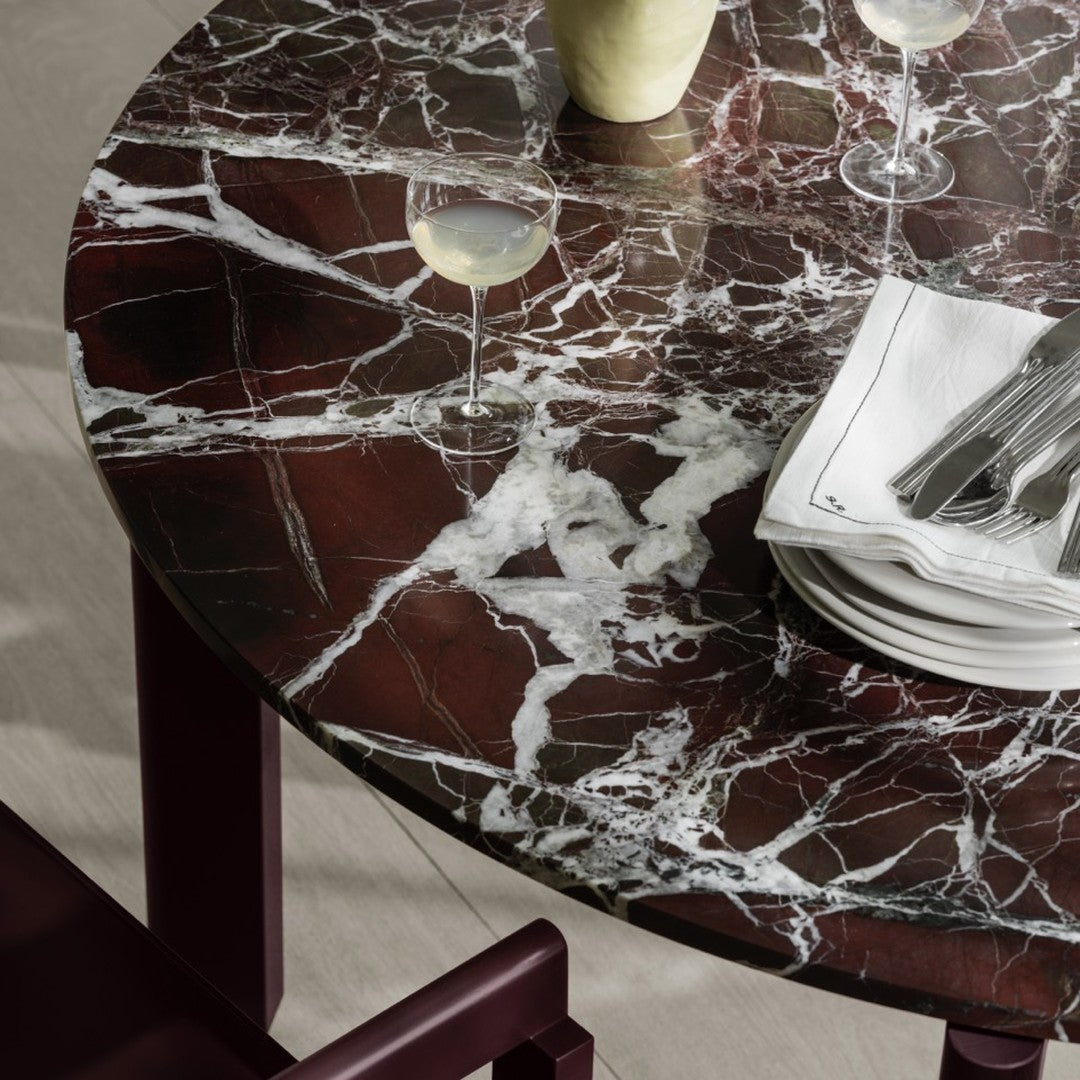 Round marble table featuring rich burgundy and white veining for a stunning contrast. Elegant and modern design details.