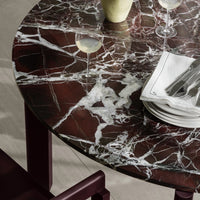 Round marble table featuring rich burgundy and white veining for a stunning contrast. Elegant and modern design details.