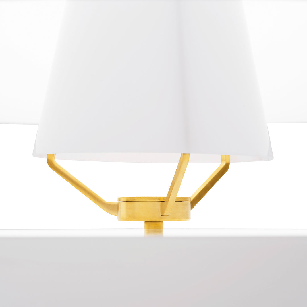 Gold geometric lamp base with a white fabric shade, creating a modern and stylish contrast.