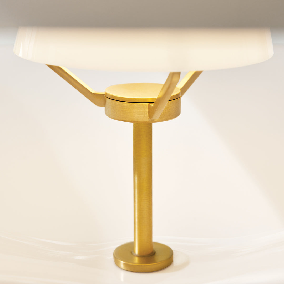 Gold table lamp base with a sleek white lampshade, featuring a modern minimalist design and smooth lines.