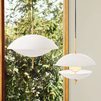 Two elegant white pendant lights with smooth, curved shapes and gold accents, set against a natural backdrop.