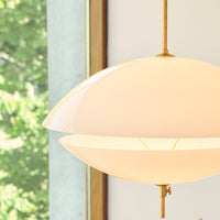 Modern white pendant lamp with a glossy finish and elegant brass accents, perfect for stylish interiors.
