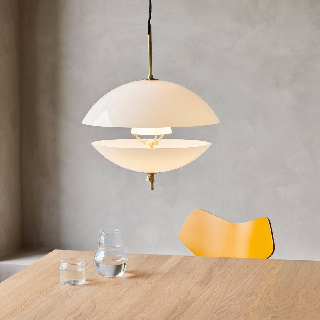 Modern white glass pendant lamp with brass accents, featuring a sleek, minimalist design and smooth surfaces.