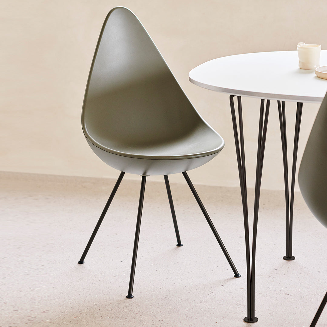Olive green modern chair with a minimalist design, set against a light beige background and black metal legs.