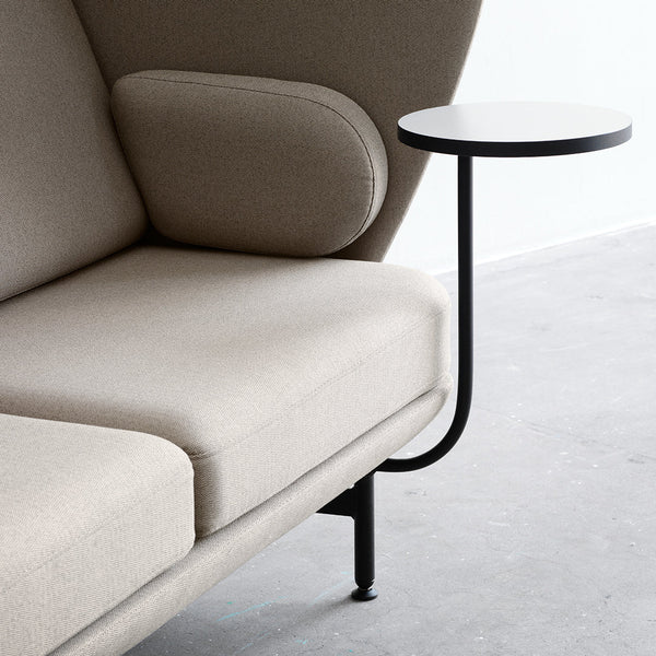 Beige upholstered sofa with a modern design, featuring a sleek black metal side table.