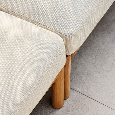 Beige textured cushions with light wood legs on a neutral tile surface. Modern and minimal design.