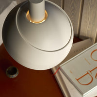 Close-up of a modern lamp on a wooden surface with books in the background